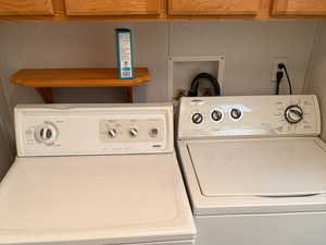 The laundry room offers ample storage with its built-in cabinets and includes a washer and dryer.