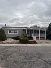 View of front facade featuring covered porch and low maintenance yard.