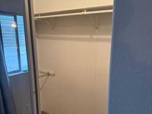 Primary bedroom closet, with mirrored doors.