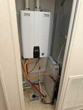 Utility room featuring tankless water heater