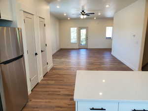 Kitchen with freestanding refrigerator, recessed lighting, white cabinetry, dark wood-type flooring, and open floor plan