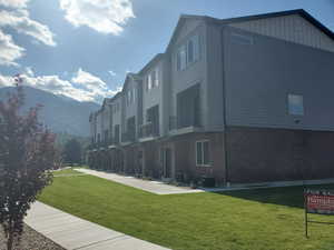 Surrounding community with a lawn, a mountain view, and a residential view