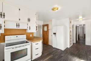 Kitchen featuring white appliances, dark wood-type flooring, white cabinetry, and light countertops