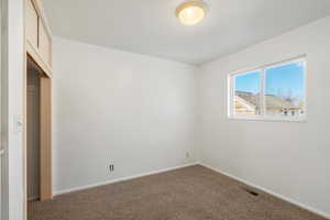 Unfurnished bedroom featuring carpet and a closet