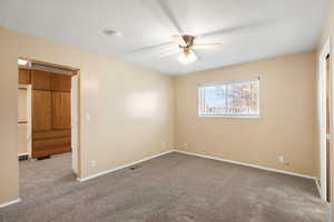 Unfurnished bedroom featuring light colored carpet, a ceiling fan, and a textured ceiling