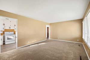 Spare room featuring carpet flooring and baseboards