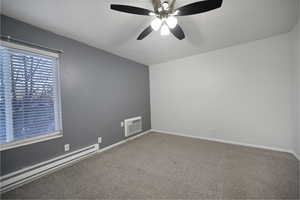 Spare room with baseboard heating, carpet flooring, ceiling fan, a textured ceiling, and an AC wall unit