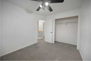 Unfurnished bedroom featuring carpet floors, a ceiling fan, and a closet