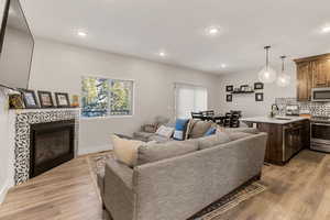 Living area with a tile fireplace, light wood-style floors, and recessed lighting