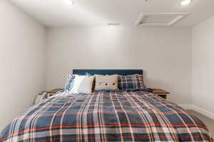 Carpeted bedroom with attic access and recessed lighting