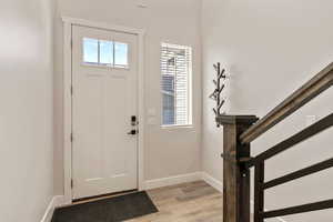 Entryway with light wood-style flooring and stairs