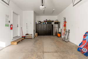 Garage with freestanding refrigerator and electric panel
