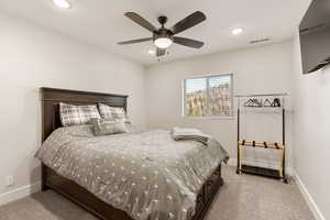 Bedroom with light colored carpet, ceiling fan, and recessed lighting