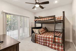 Bedroom featuring light carpet, access to exterior, a ceiling fan, and recessed lighting