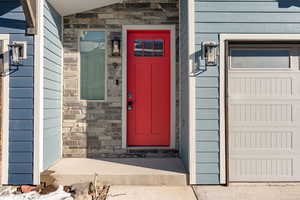 Entrance to property featuring stone siding