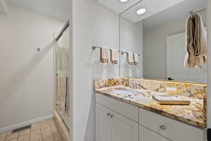 Bathroom featuring vanity and a shower stall