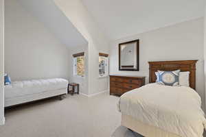 Bedroom with carpet flooring and vaulted ceiling
