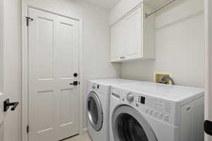 Laundry room featuring independent washer and dryer and cabinet space