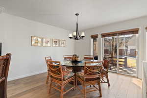 Dining room with a chandelier, hardwood / wood-style floors, and a textured ceiling