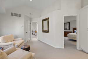 Living area featuring lofted ceiling and light carpet