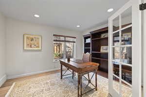Office area featuring light wood-style flooring and recessed lighting