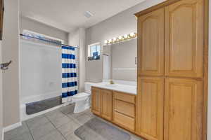 Full bathroom featuring vanity, shower / bath combo, and light tile patterned floors