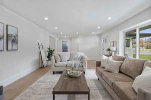 Living room featuring recessed lighting, light wood-style flooring, and a textured ceiling