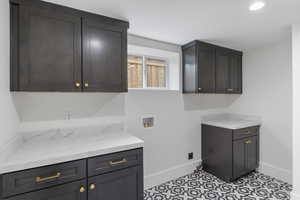 Laundry area with washer hookup, cabinet space, and recessed lighting