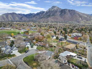 Aerial view of property and surrounding area featuring nearby suburban area and mountains
