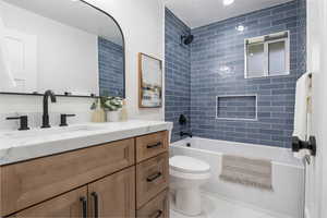 Bathroom with vanity, bathing tub / shower combination, tile patterned floors, and a textured ceiling