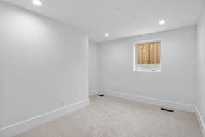 Spare room with light carpet and recessed lighting