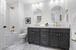 Bathroom featuring double vanity,  shower combination, and light marble finish floors