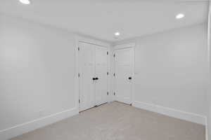 Unfurnished bedroom featuring carpet floors, recessed lighting, and a closet