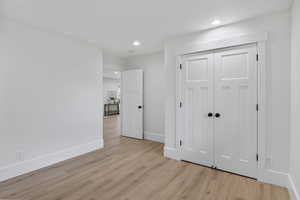 Unfurnished bedroom featuring recessed lighting, light wood-style flooring, and a closet