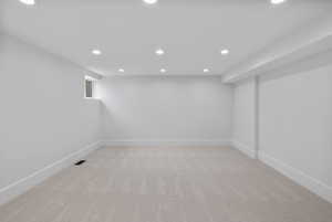 Basement featuring recessed lighting and light carpet