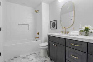 Full bathroom with bathing tub / shower combination, vanity, and light marble finish flooring