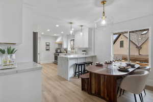 Dining room with light wood-style floors and recessed lighting