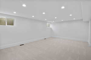Basement with recessed lighting and light colored carpet