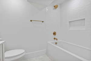 Full bath with washtub / shower combination, light tile patterned floors, and vanity