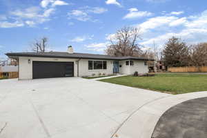 Single story home featuring brick siding, concrete driveway, a chimney, an attached garage, and roof with shingles