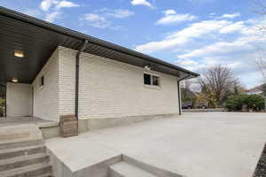 View of home's exterior with brick siding and a patio