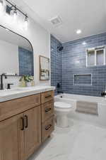 Bathroom with vanity, tub / shower combination, a textured ceiling, recessed lighting, and light marble finish flooring
