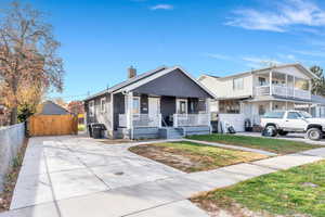 View of front facade featuring a porch, a chimney, and driveway