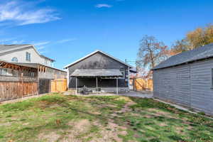 Rear view of property with a patio area, a fenced backyard, and a gate