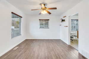 Unfurnished room featuring wood finished floors, a textured ceiling, healthy amount of natural light, and ceiling fan