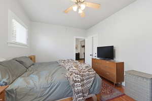 Bedroom with dark wood-type flooring and ceiling fan