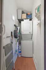 Washroom featuring stacked washer / dryer and light wood-style floors