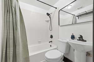 Bathroom featuring shower / tub combo and toilet