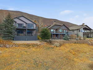 Back of property featuring a balcony and a mountain view