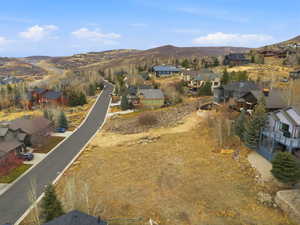 Aerial view of property and surrounding area with mountains and nearby suburban area